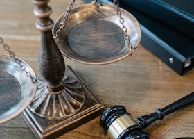 From above of judicial symbols consisting of Scales of Justice and small judge hammer with curly handle